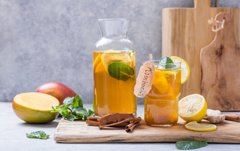 Glass of Kombucha of a table full of ingredients